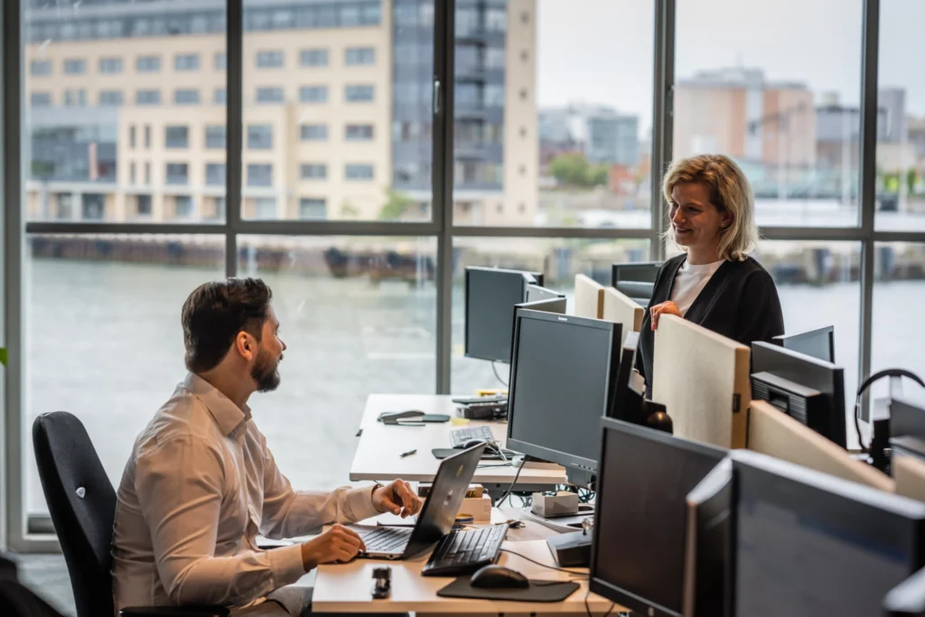 Ett kontor med en teknisk förvaltare och en ekonomisk förvaltare som samtalar.