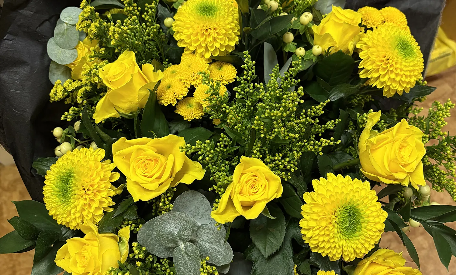 Gula blommor i olika variationer i en bukett.