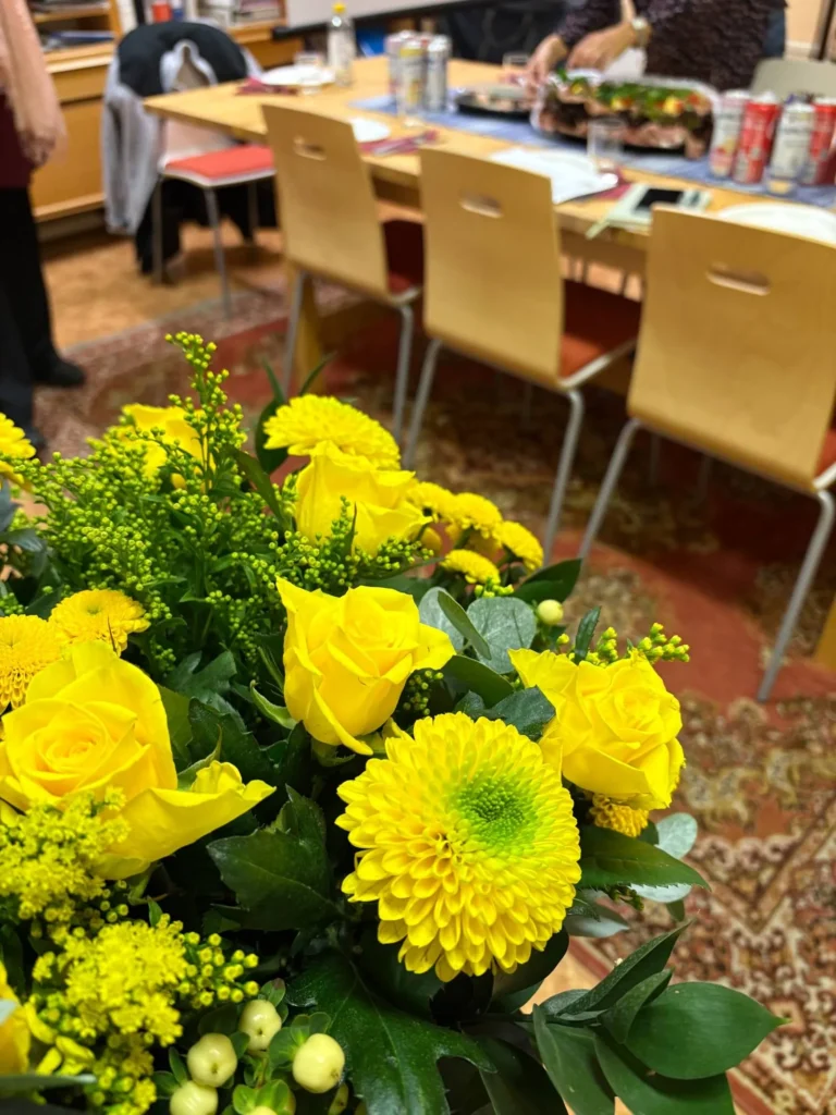 Gula blommor med uppdukat bord till styrelsemötet i bakgrunden.